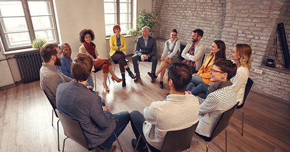 Group therapy session with participants sitting in a circle.