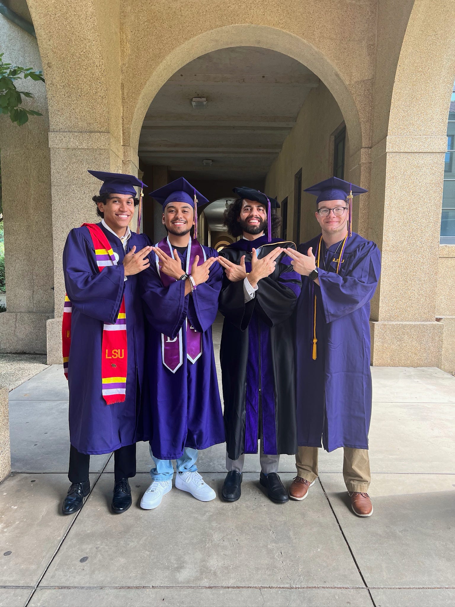 Sigma Lambda Beta members in caps and gowns on campus