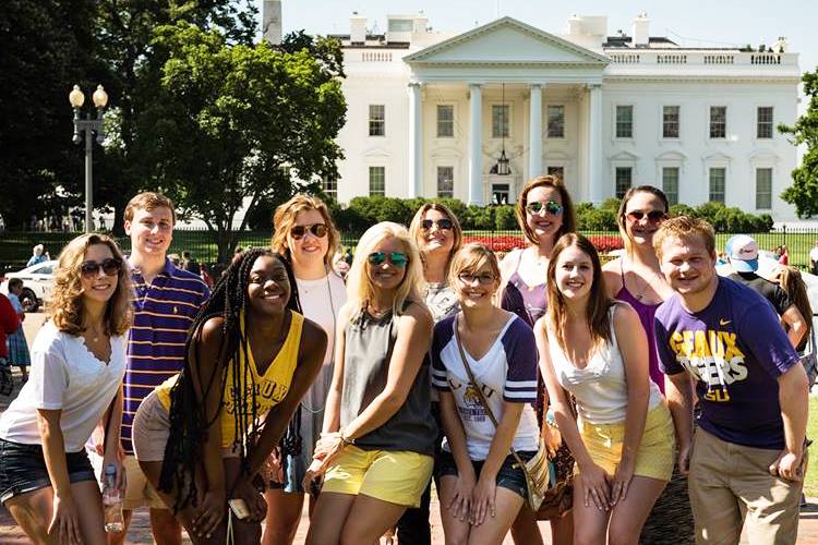 Students smiling in front of the White House